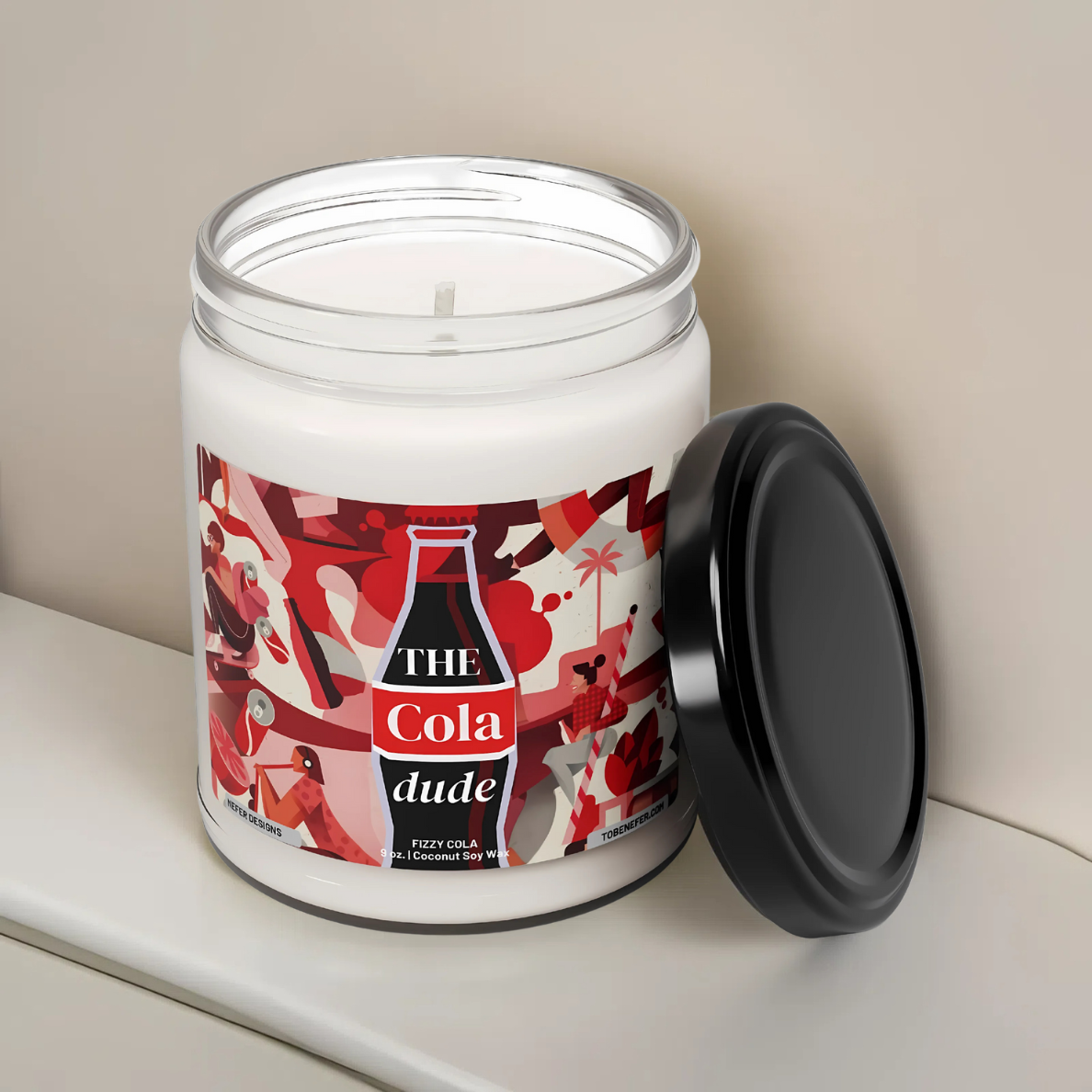 A 9oz Cola Dude Soda Pop Soy Candle in a jar, featuring a bold red design. Hand-poured with a coconut and soy wax blend, it fills the air with the nostalgic scent of classic cola. A fun gift for soda lovers and vintage fans.