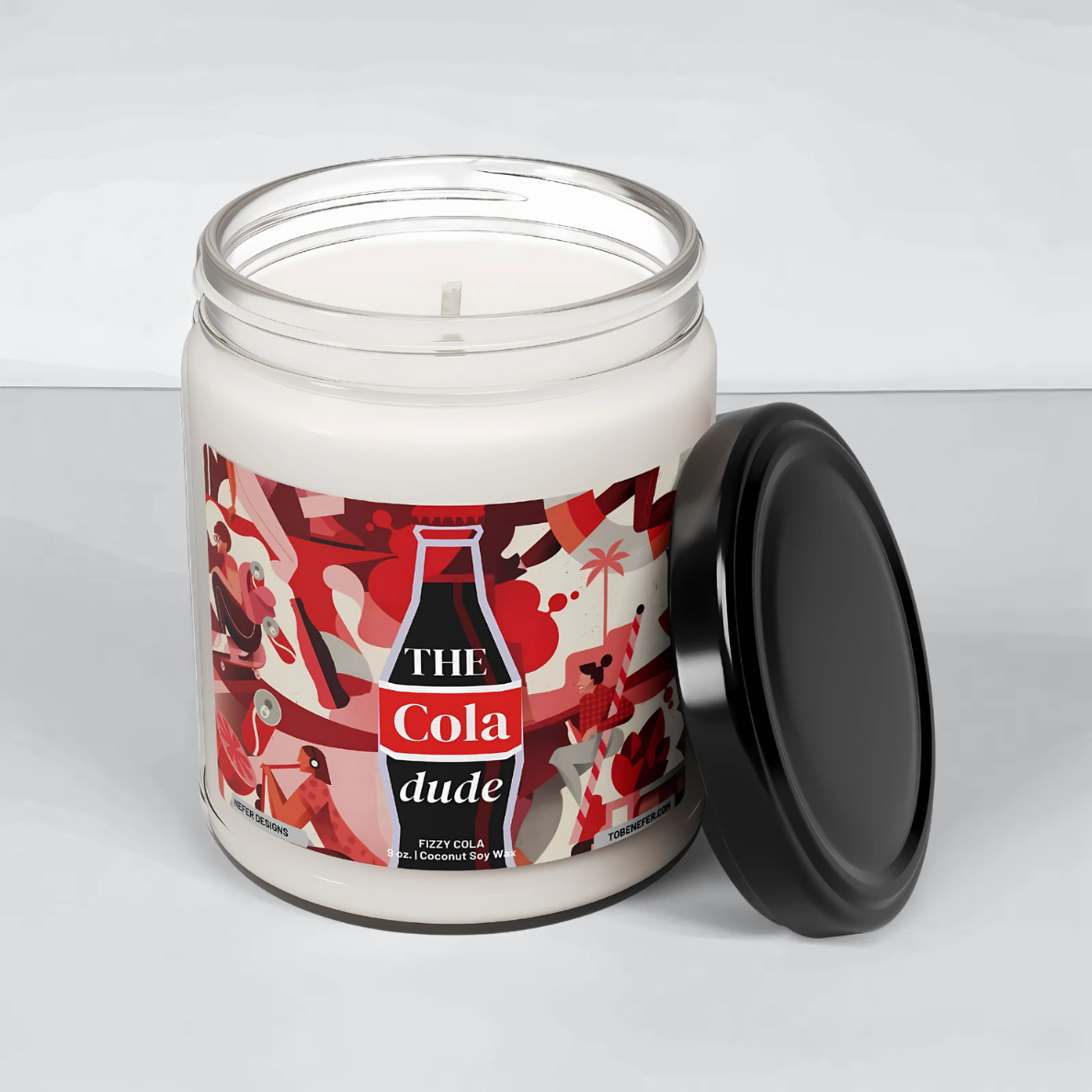 A 9oz Cola Dude Soda Pop Soy Candle in a jar, featuring a bold red design. Hand-poured with a coconut and soy wax blend, it fills the air with the nostalgic scent of classic cola. A fun gift for soda lovers and vintage fans.