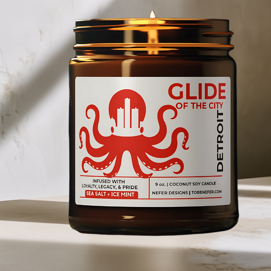 Candle in a brown jar with a red and white label featuring an octopus design, on a light background.
