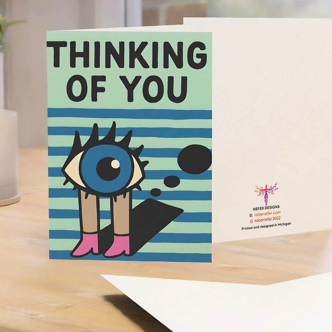 Greeting card with cartoon character and 'Thinking of You' text on a striped background