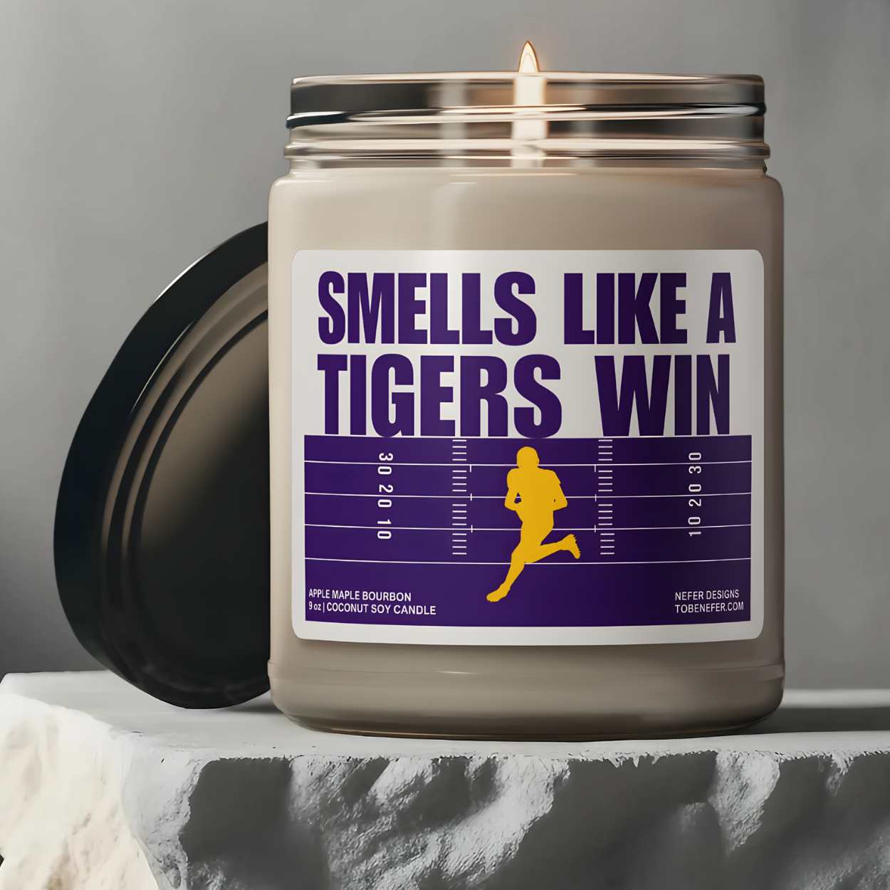 Louisiana tigers game day candle with the purple and yellow team colors on the label saying smells like a tigers win