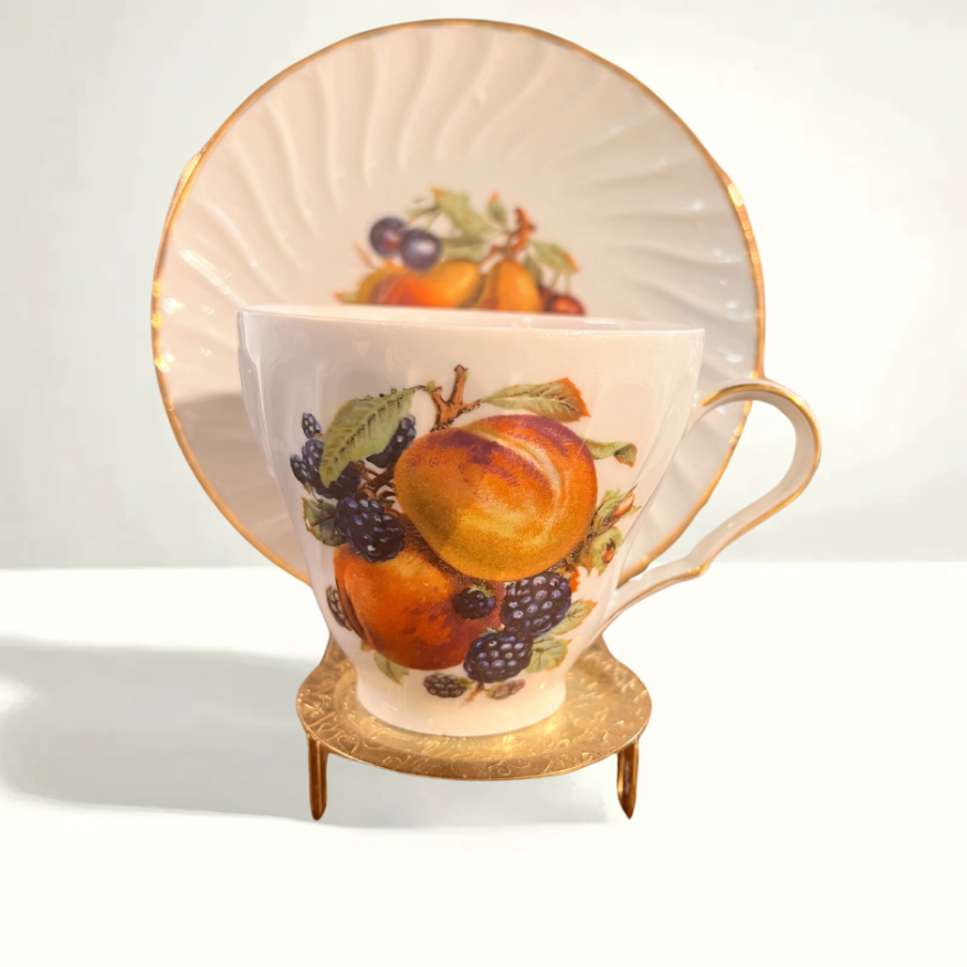 Vintage Old Nuremberg teacup and saucer set with vibrant fruit design featuring apples, grapes, and pears on glossy German porcelain