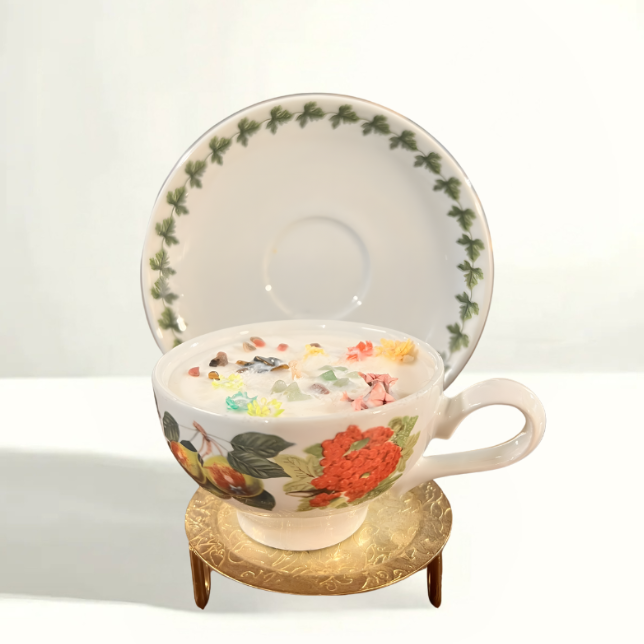 Hand-poured soy wax candle in a vintage Portmeirion Botanic Garden teacup from England, featuring botanical floral illustrations and a classic white saucer