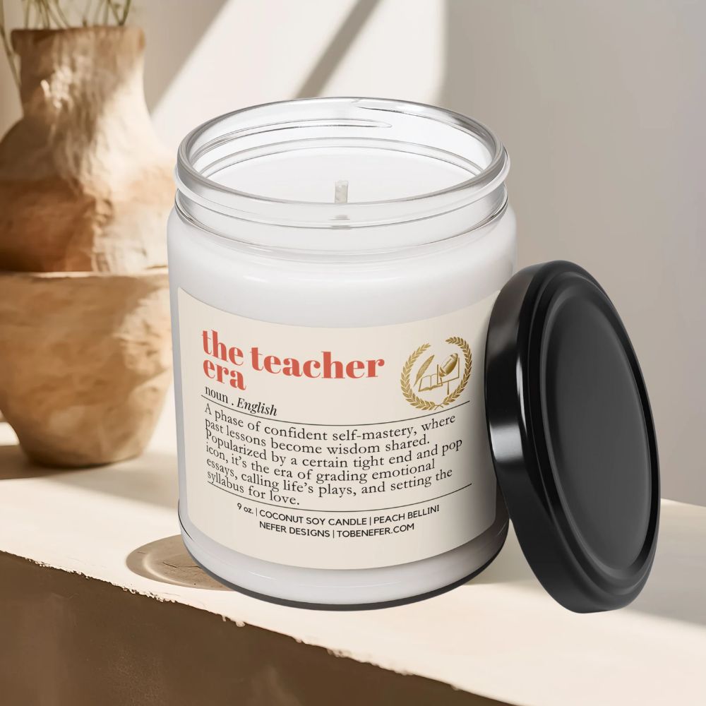 Candle in a jar with a label titled 'the teacher era' on a shelf.