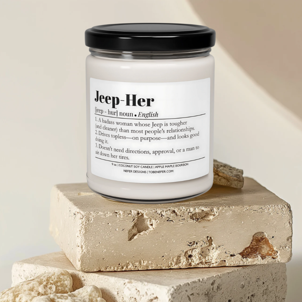 Jeep-Her Soy Candle in a clear with a black lid presented with a textured rock surface.