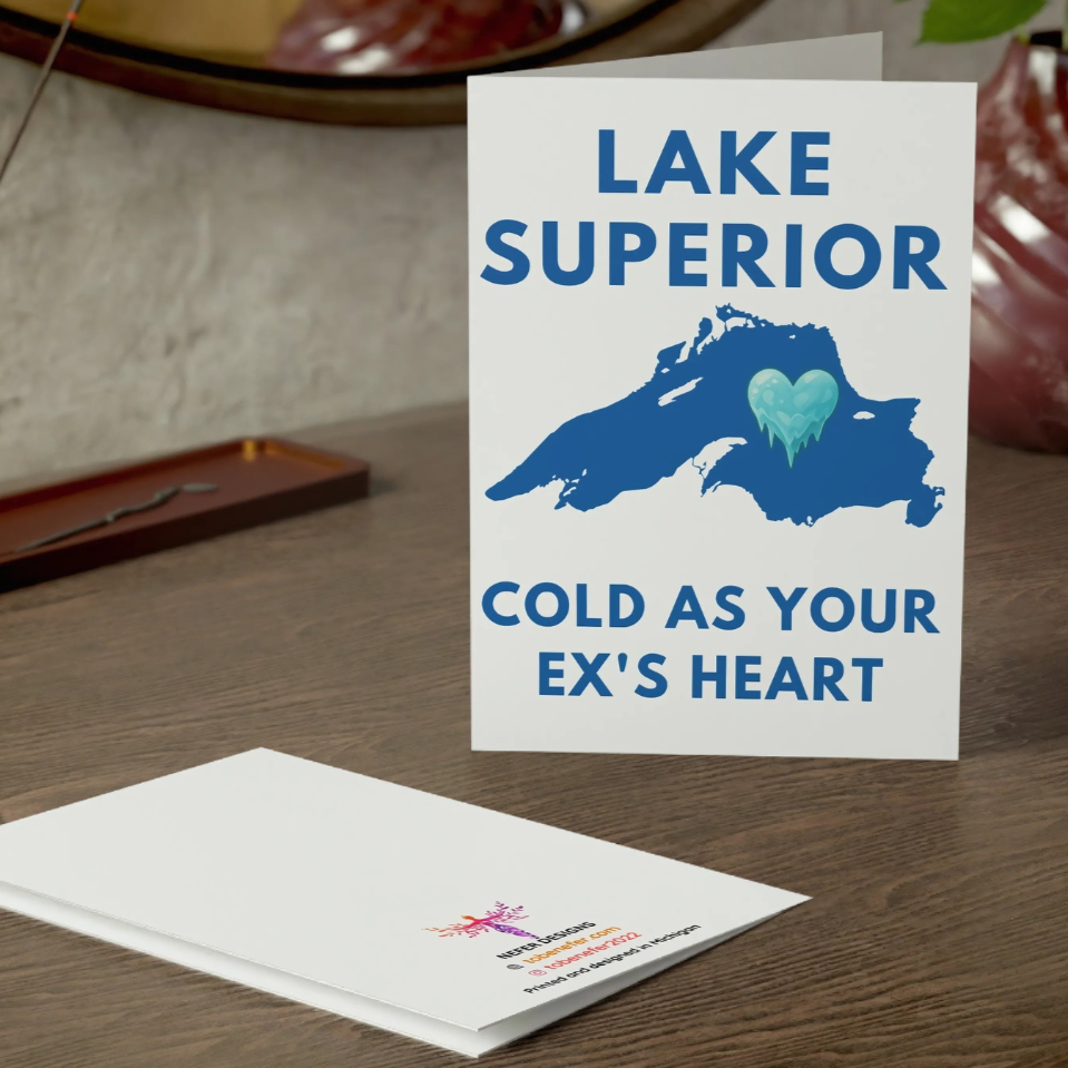 Card with 'Lake Superior Cold as your ex's heart' design on a wooden surface
