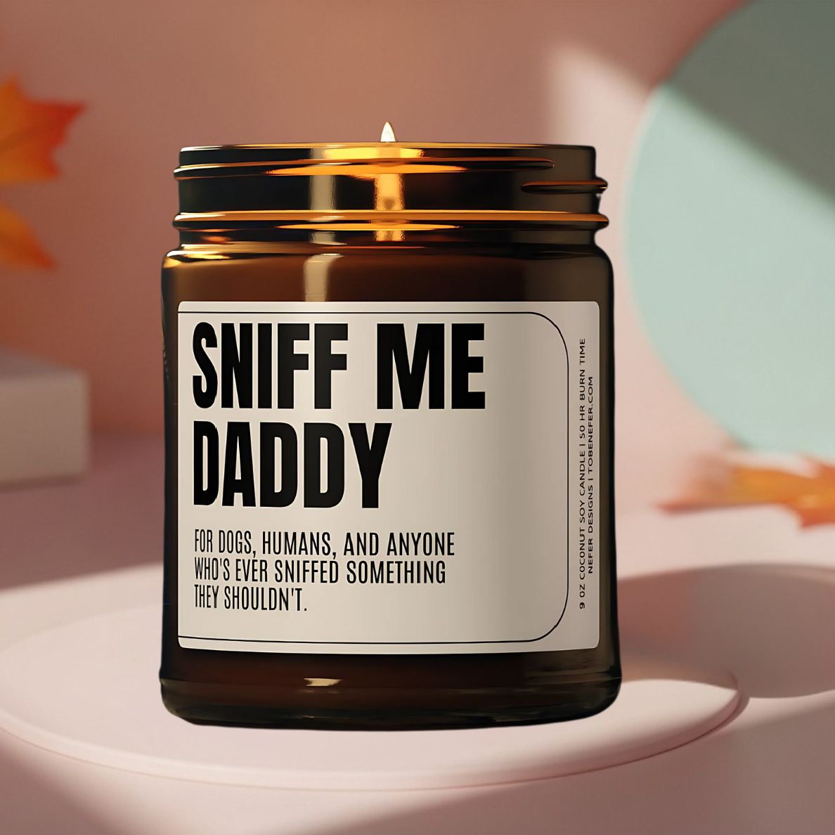 Sniff Me Daddy gag gift candle surrounded by decorative pumpkins, creating a festive holiday atmosphere