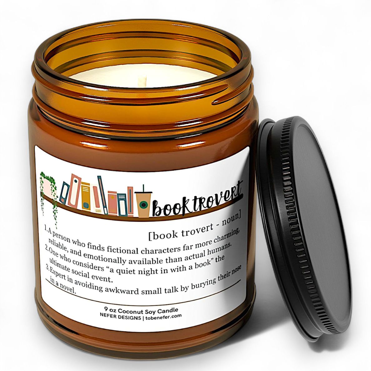 Candle in an amber jar with a label featuring the definition of booktrovert on a white background