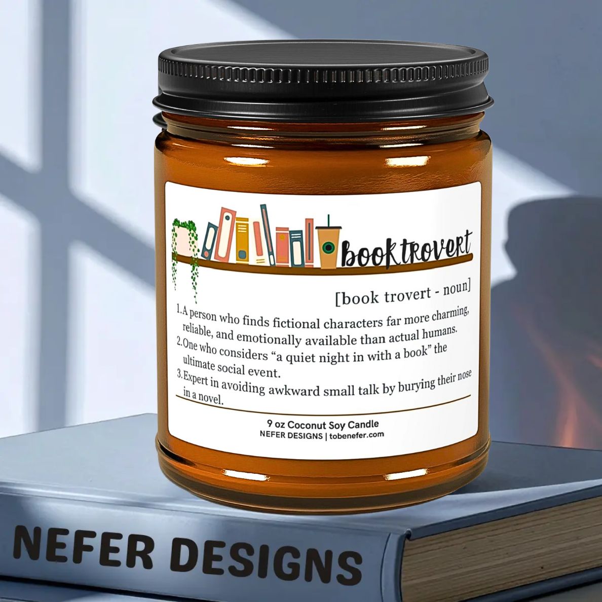 Jar candle with 'booktrovert' label on a book, against a blurred window background