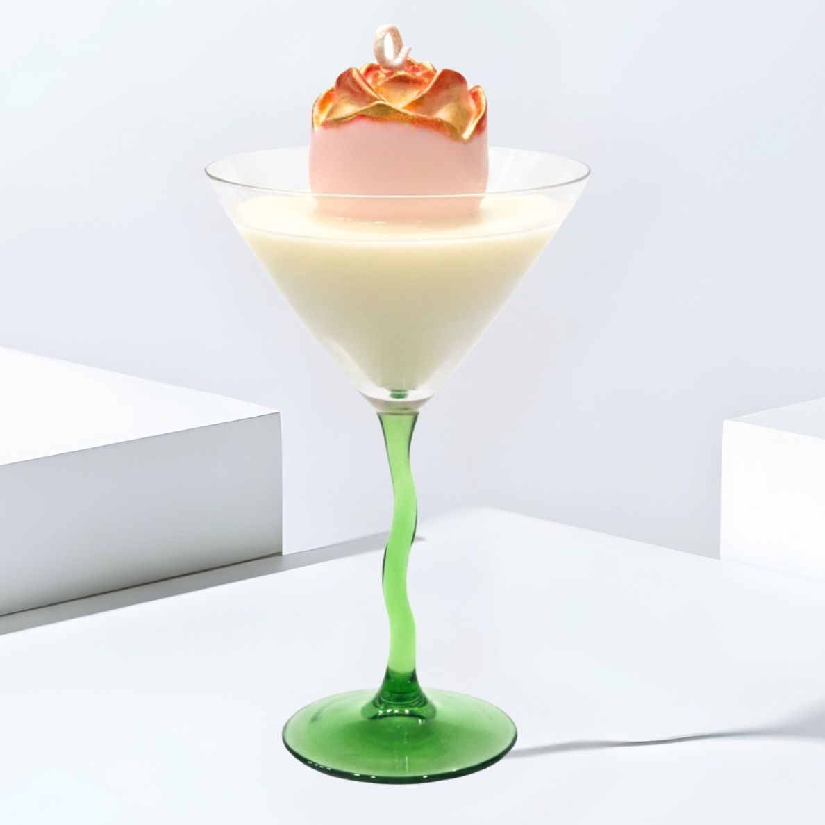 Clean studio shot of the Gilded Rose Martini luxury candle in a green wavy-stem glass, highlighting the pink wax rose with gold accents on a white background.