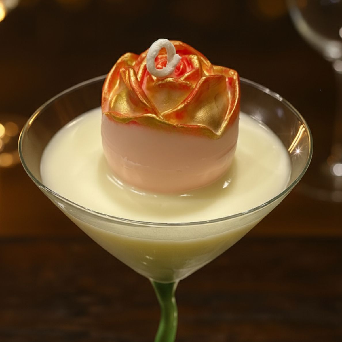 Extreme close-up of the Gilded Rose Martini candle, highlighting the texture and gold detail of the central rose embed and the creamy white wax base.