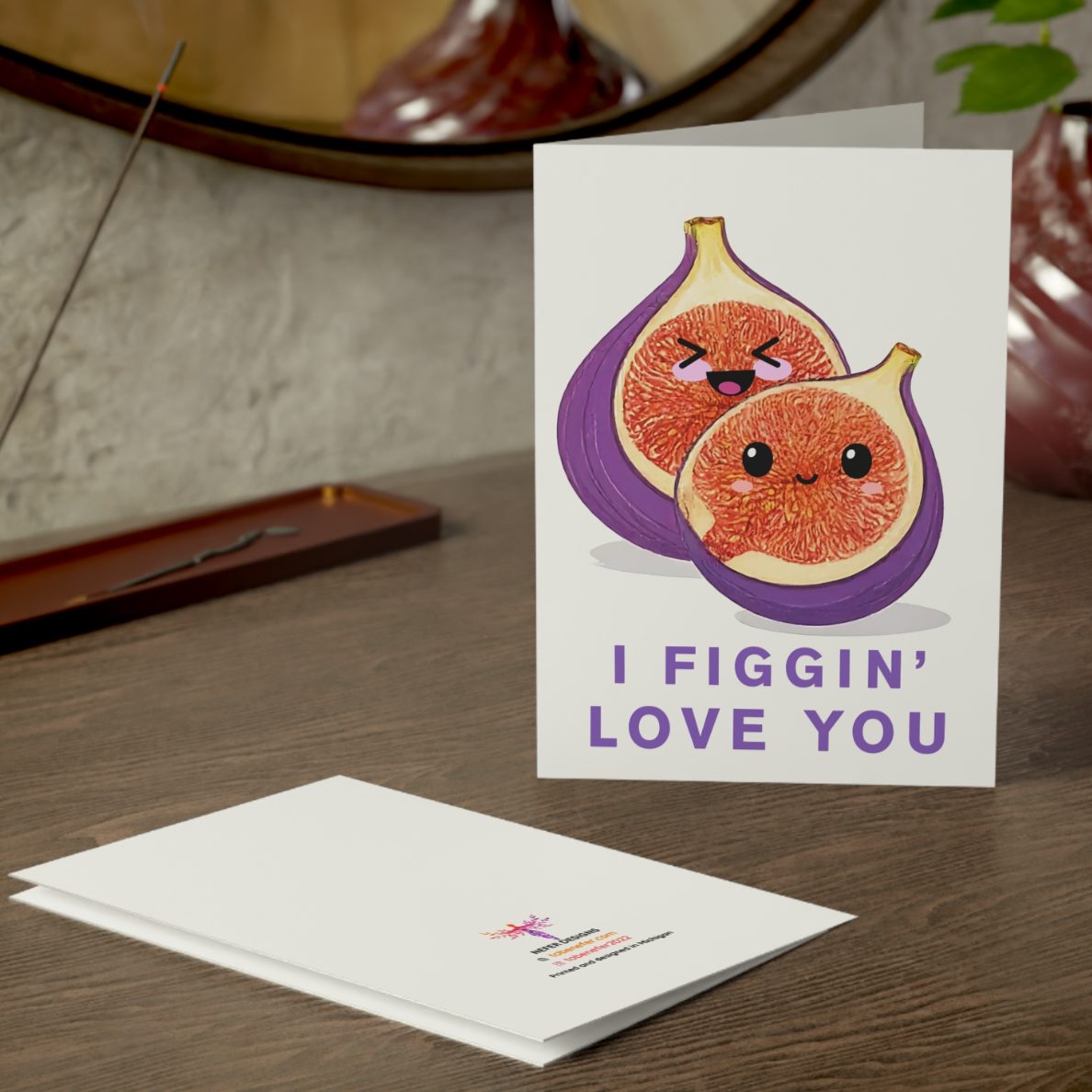 Greeting card with fig illustration and text 'I Figgin' Love You' on a wooden surface.