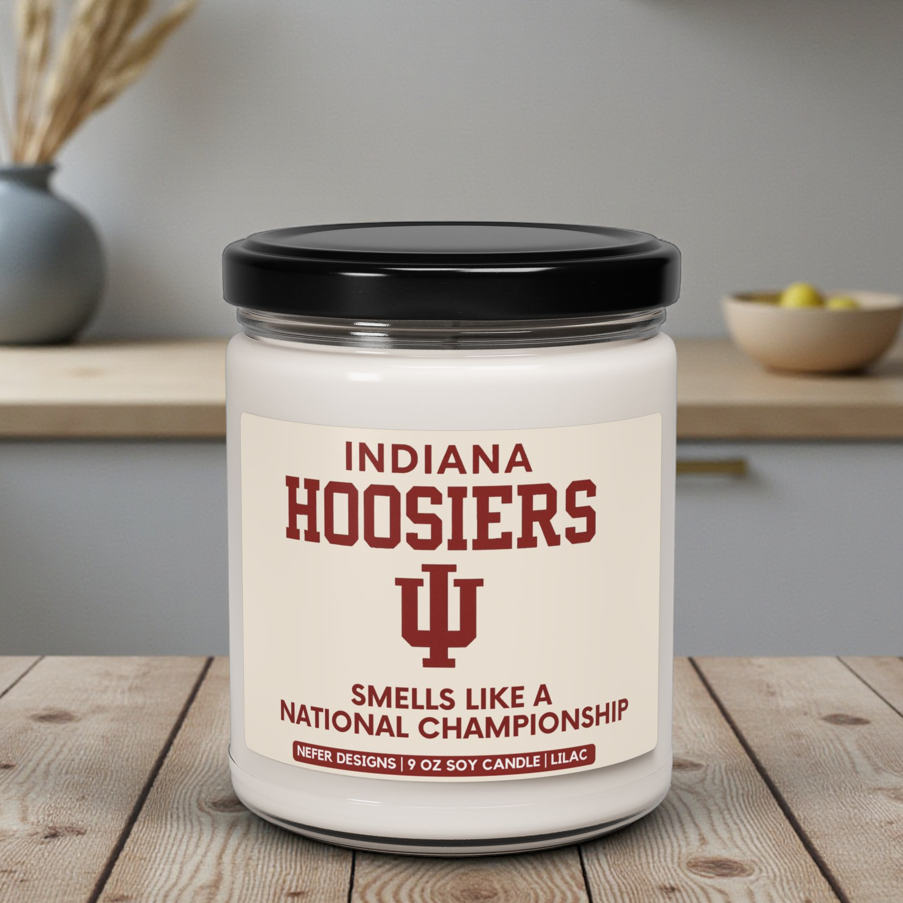 Candle with Indiana Hoosiers branding on a wooden surface