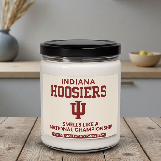 Candle with Indiana Hoosiers branding on a wooden surface