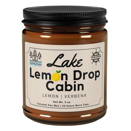 Amber glass jar of Lake Lemon Drop soy candle by Nefer Designs, featuring lemon verbena scent with 9oz coconut soy wax (50-hour burn time) for cabin relaxation.
