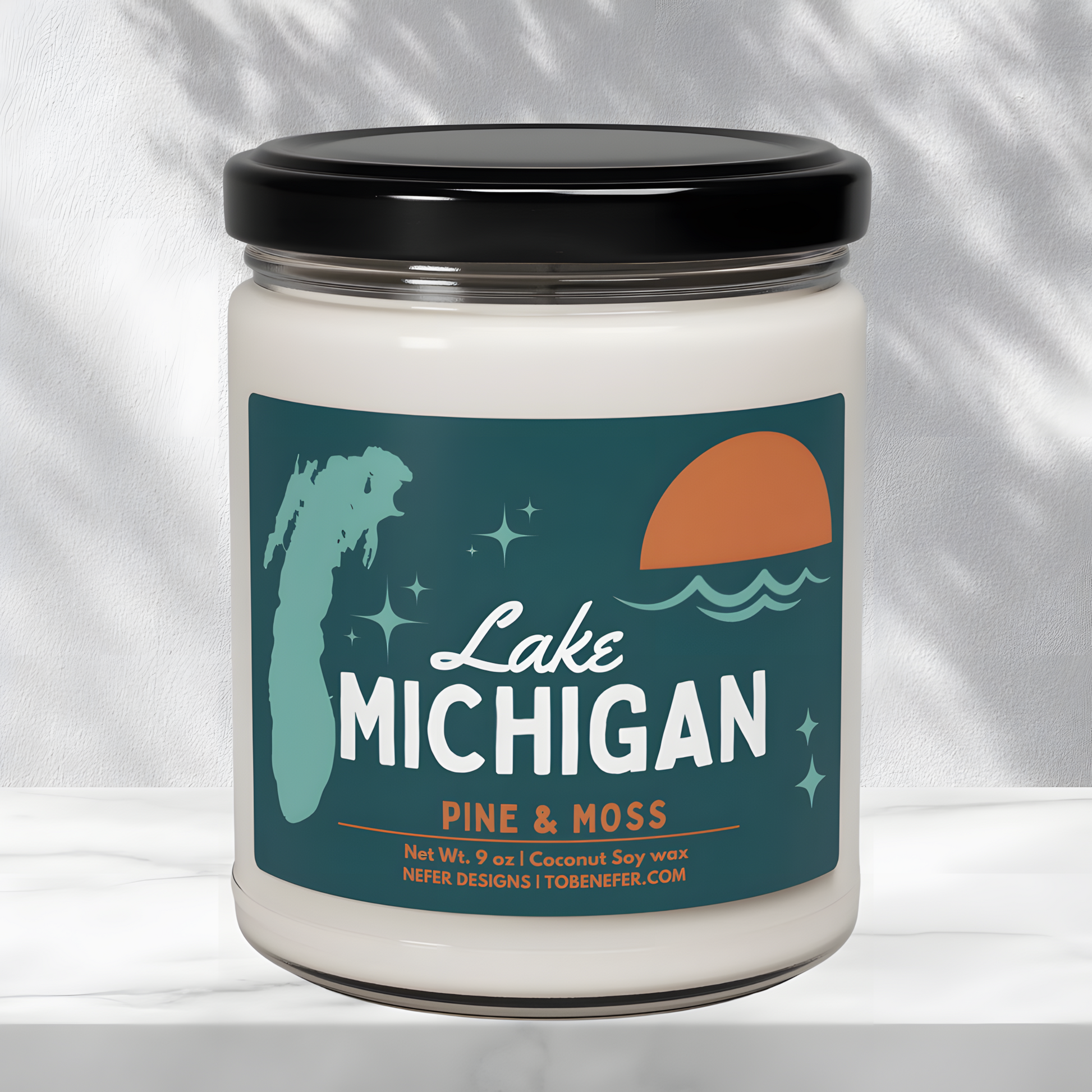 Close-up of the 'Lake Michigan' candle label, highlighting the 'Pine & Moss' scent, 9 oz coconut soy wax composition, and Nefer Designs branding.
