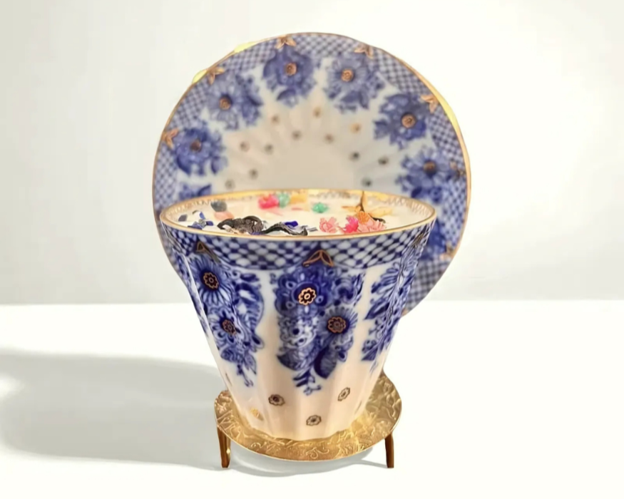 Elegant candle poured into a Lomonosov Cobalt Net porcelain teacup from Russia, featuring hand-painted blue and gold lattice design with delicate white porcelain and matching saucer