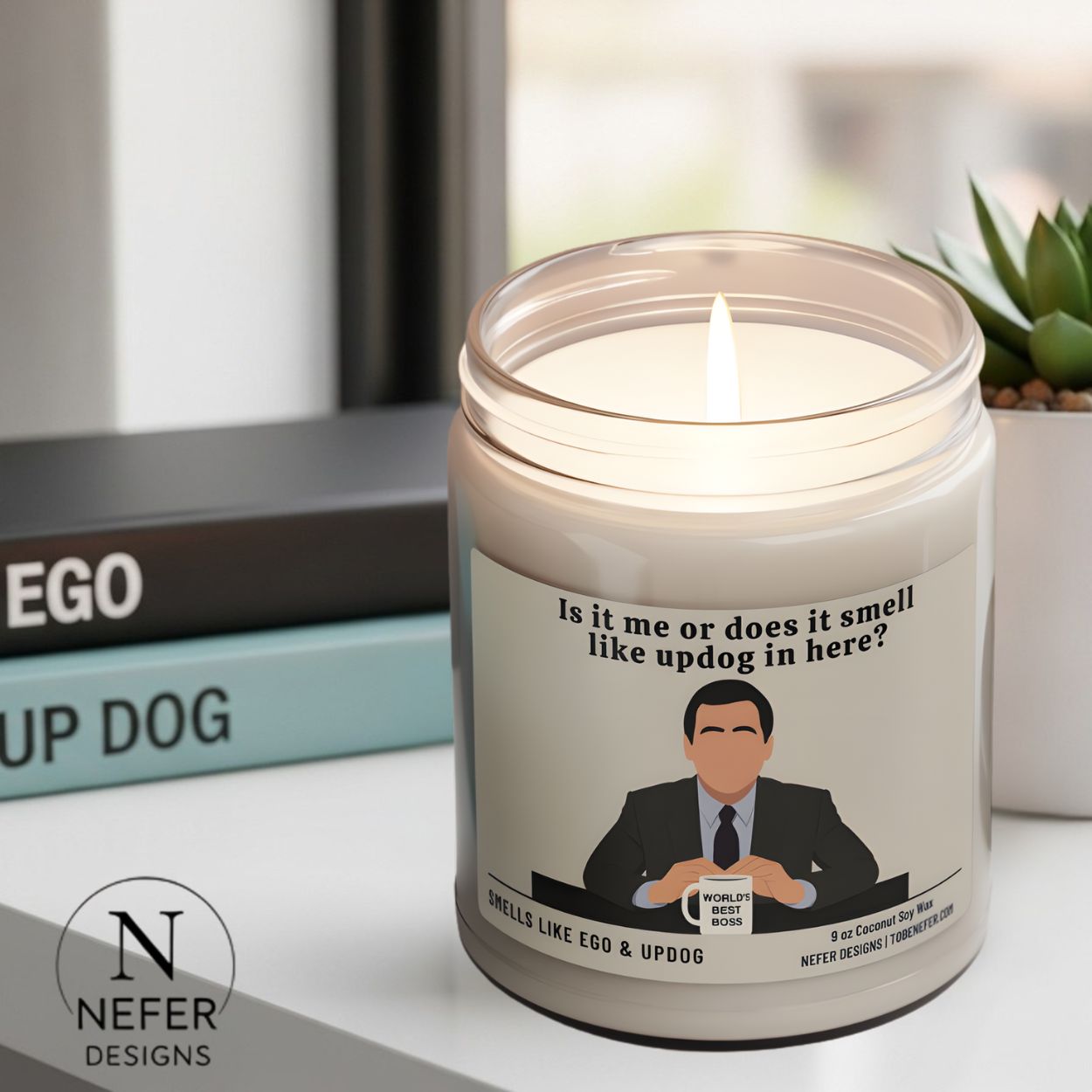 The office show themed candle sitting next to books named as ego and up dog.