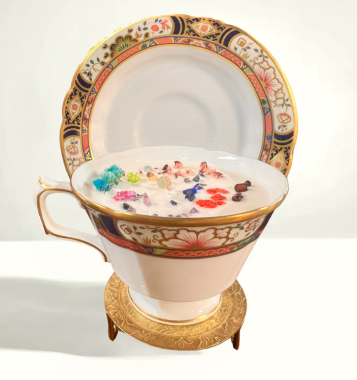 Luxurious soy candle set in a Royal Crown Derby Chelsea Garden teacup from England, adorned with pastel floral patterns, fine gold detailing, and a matching bone china saucer.