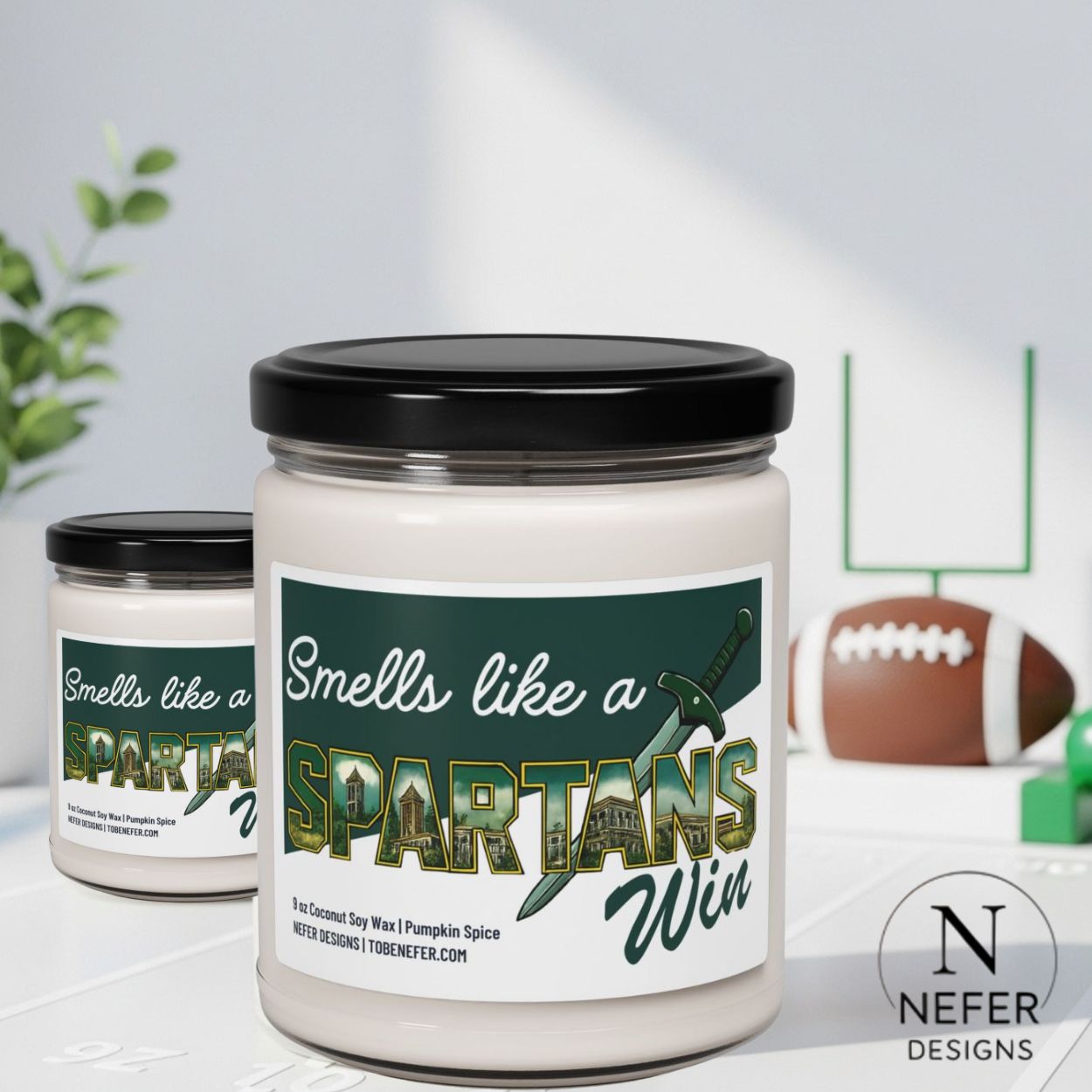 Candle jar with 'Smells like a Spartans Win' label on a surface with sports-themed decor.
