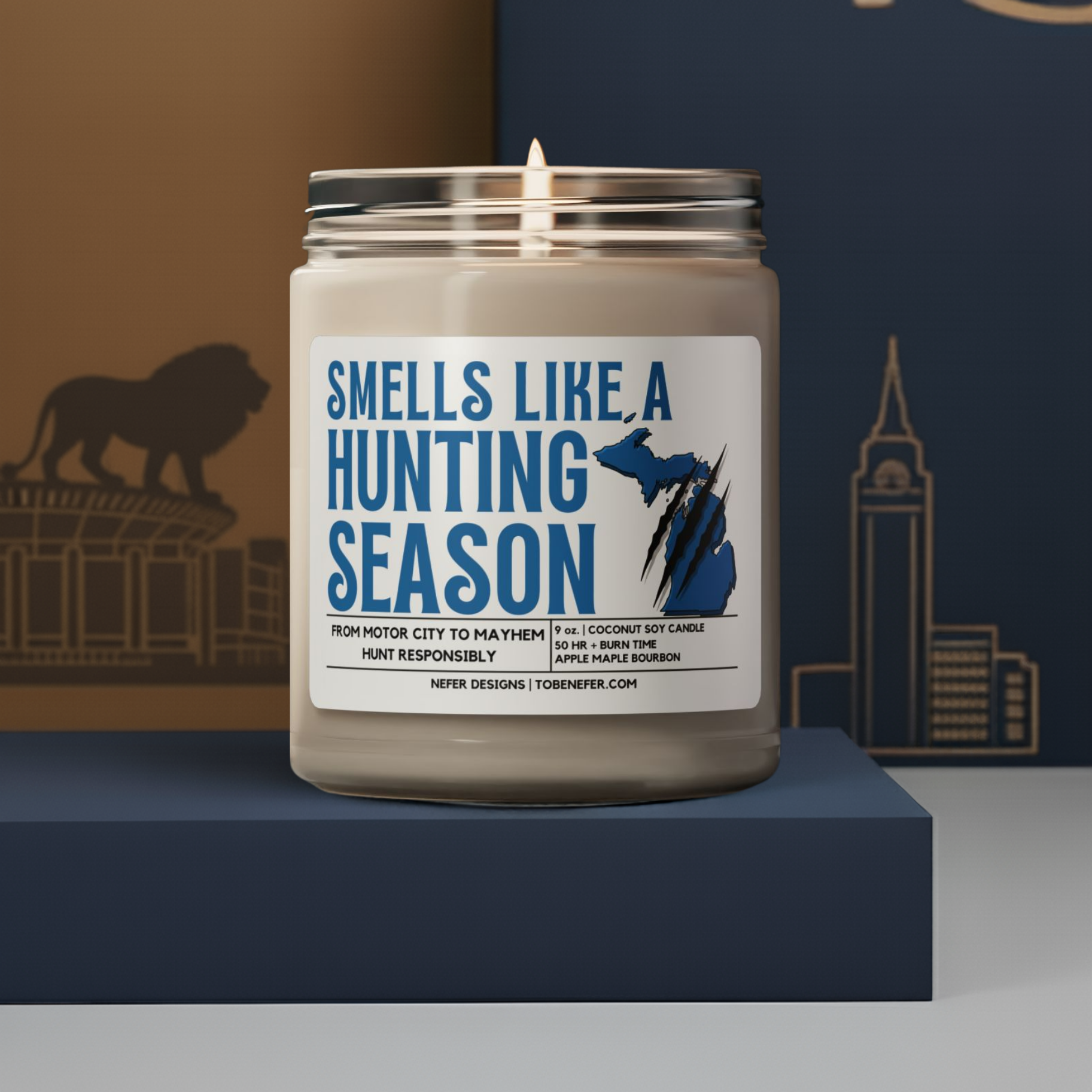 Candle in a jar with a label reading 'Smells Like a Hunting Season' on a blue platform.