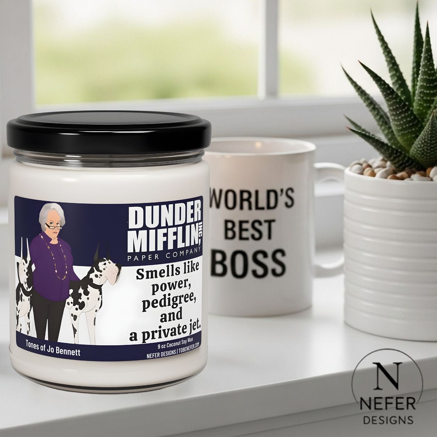 Candle with 'Dunder Mifflin' branding and a mug with 'World's Best Boss' text on a windowsill.