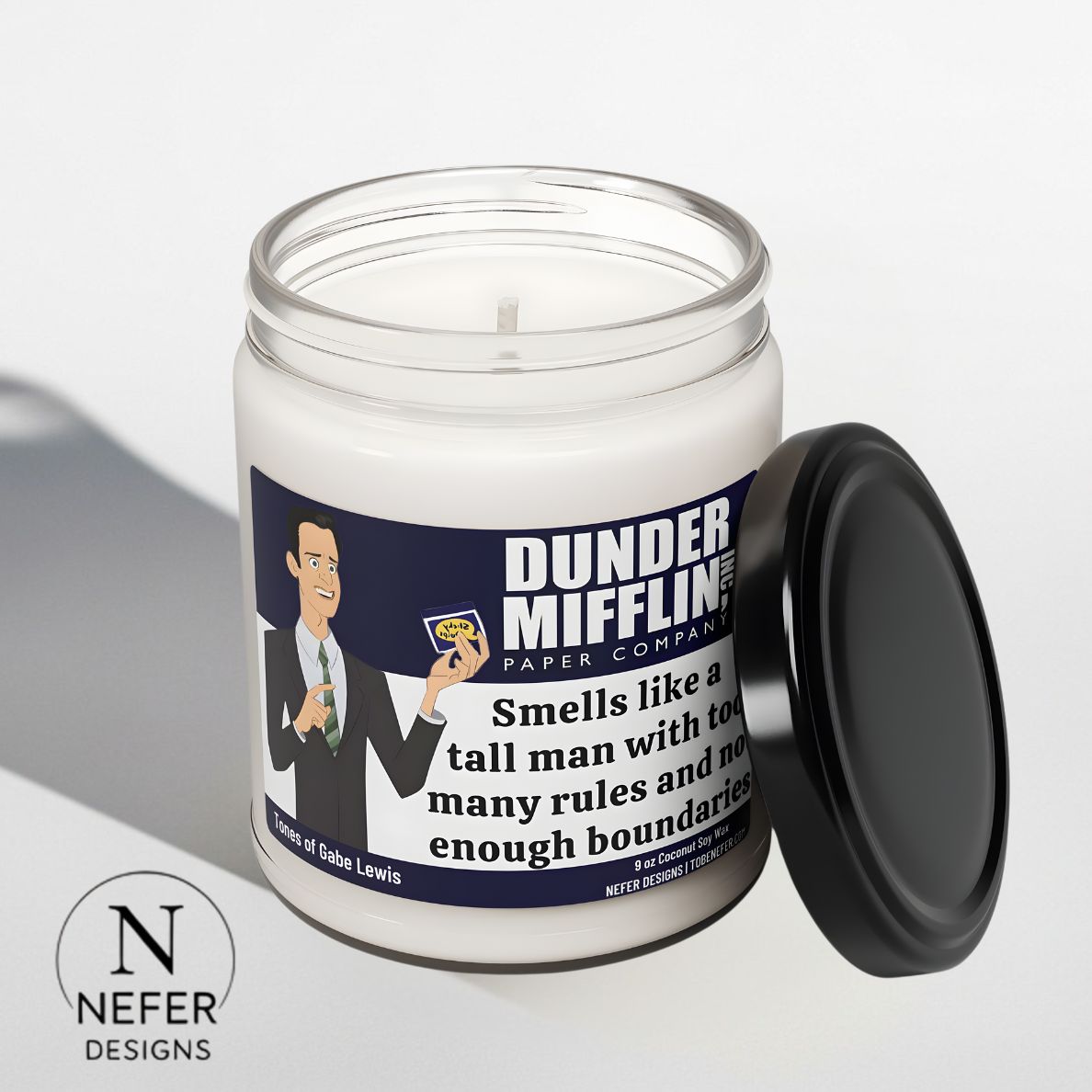 Scented candle with a 'Dunder Mifflin' label featuring a  Gabe Lewis character from 'The Office' on a white background.