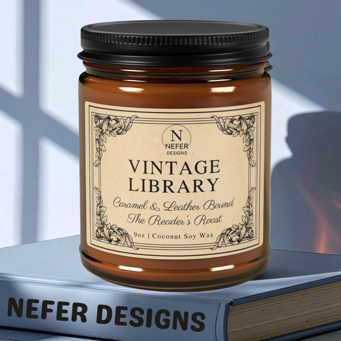 Candle jar labeled 'Vintage Library' by Nefer Designs on a book with a blurred window background.