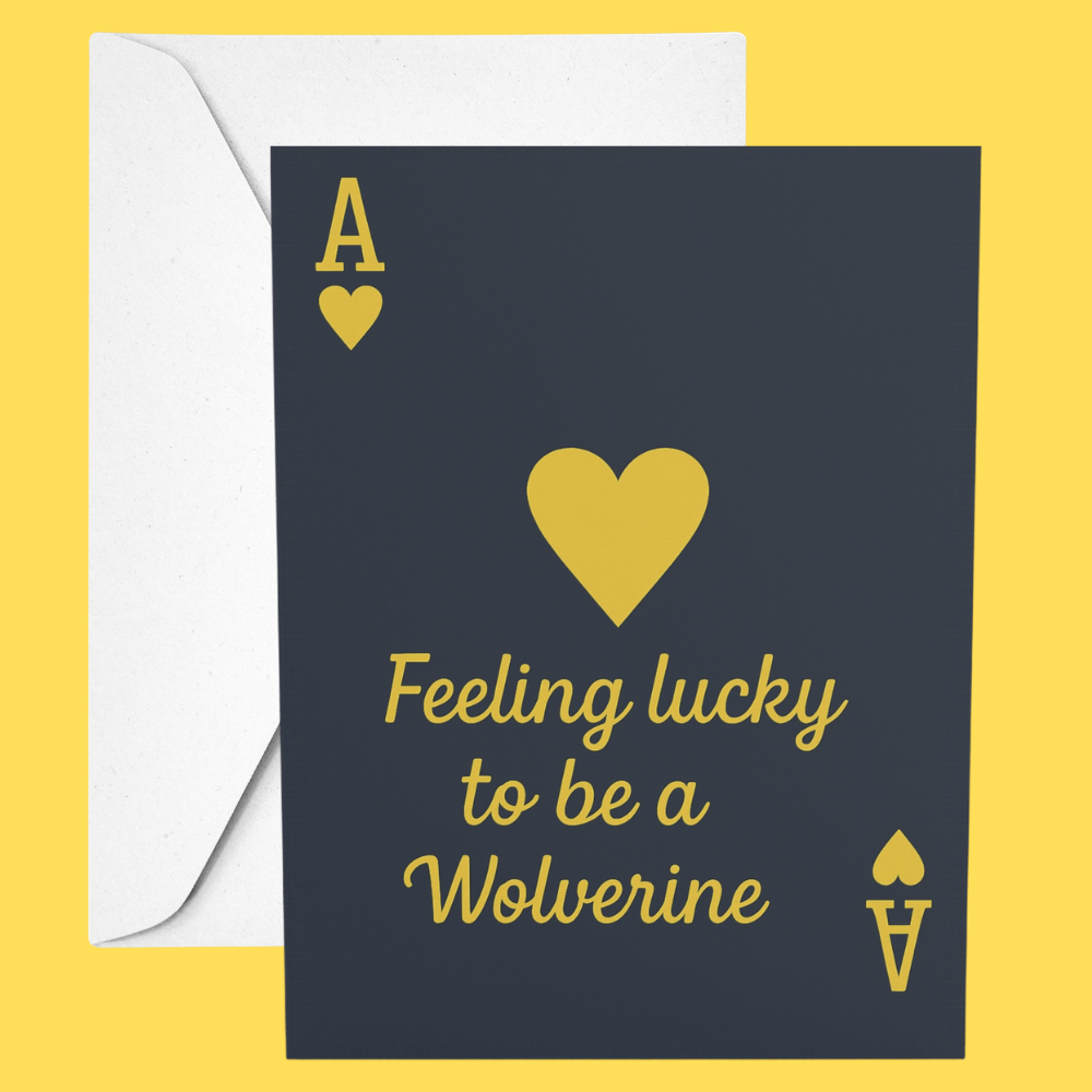 Card with a yellow heart and text 'Feeling lucky to be a Wolverine' on a dark blue background, with a white envelope.