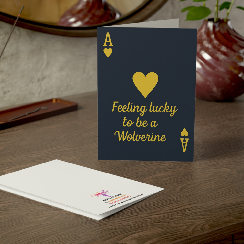 Greeting card with 'Feeling lucky to be a Wolverine' text on a wooden surface