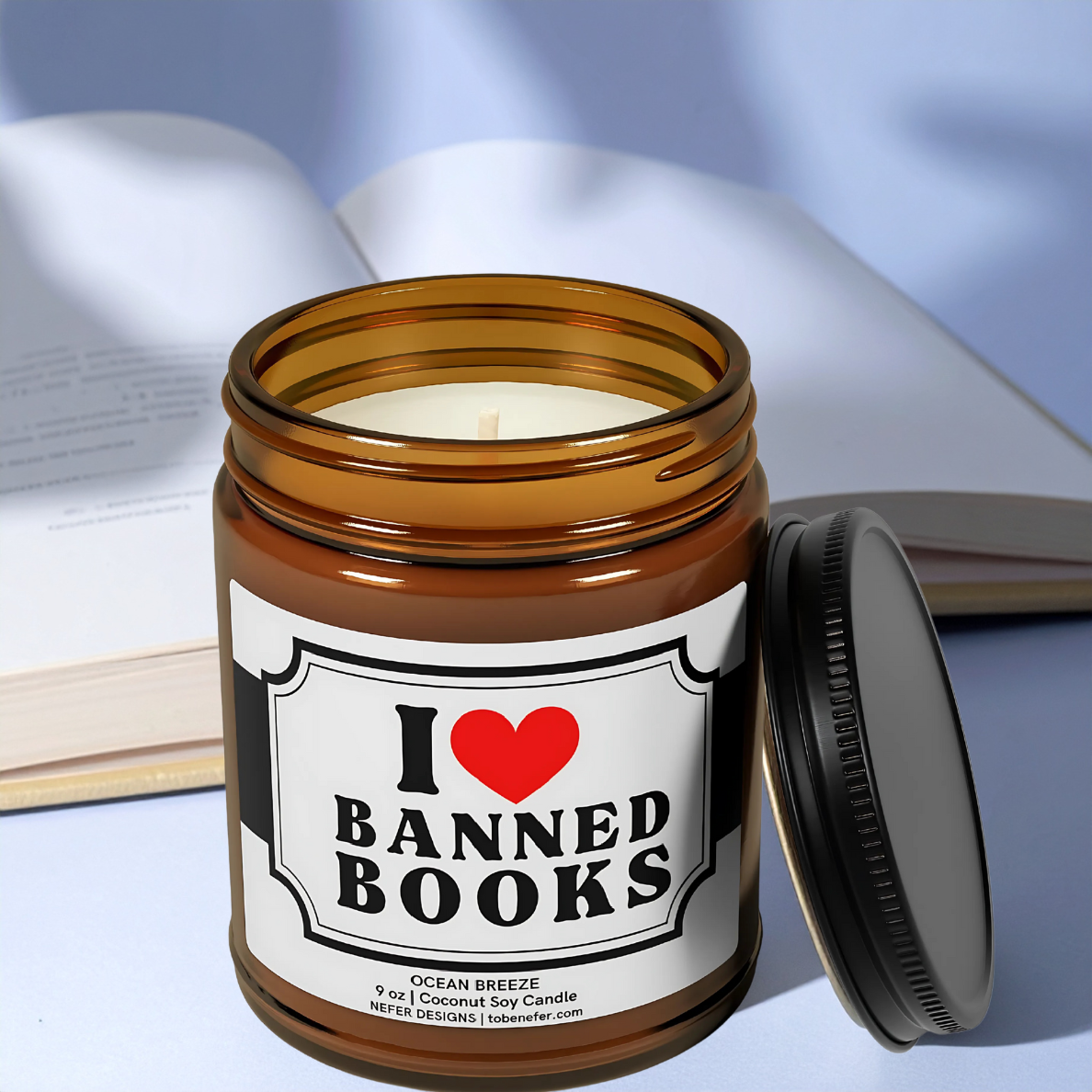 9 oz amber jar candle for banned book lovers, set against a backdrop of a book.